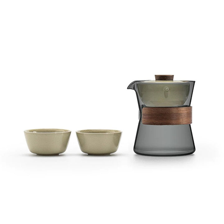 Tea set with a glass teapot and two ceramic cups on a white background