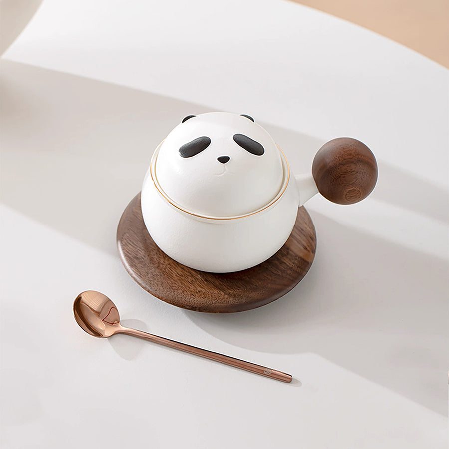 Panda-shaped ceramic container with wooden lid and spoon on a light background