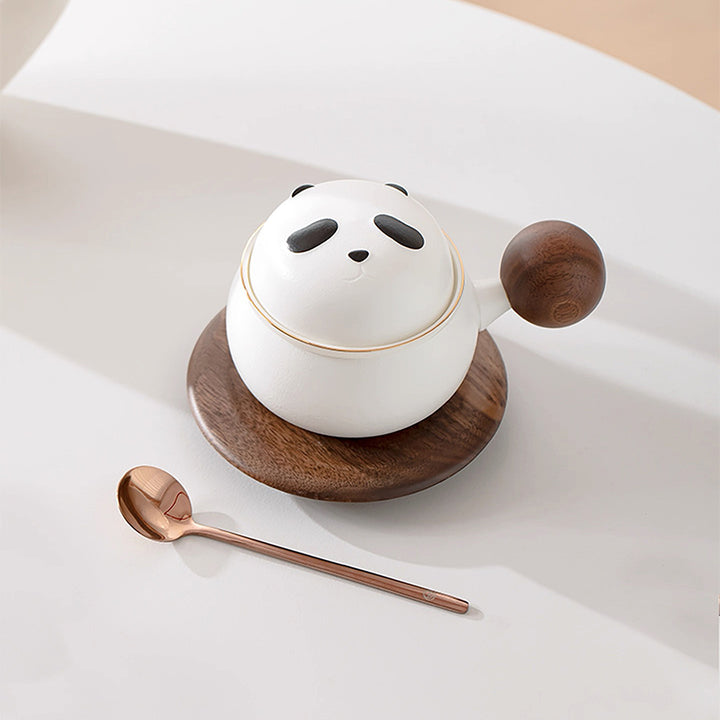 Panda-shaped ceramic container with wooden lid and spoon on a light background