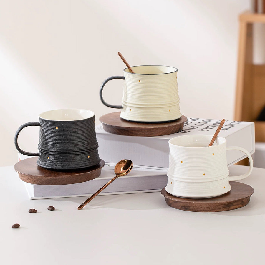 Three ceramic mugs with wooden coasters on a white surface.
