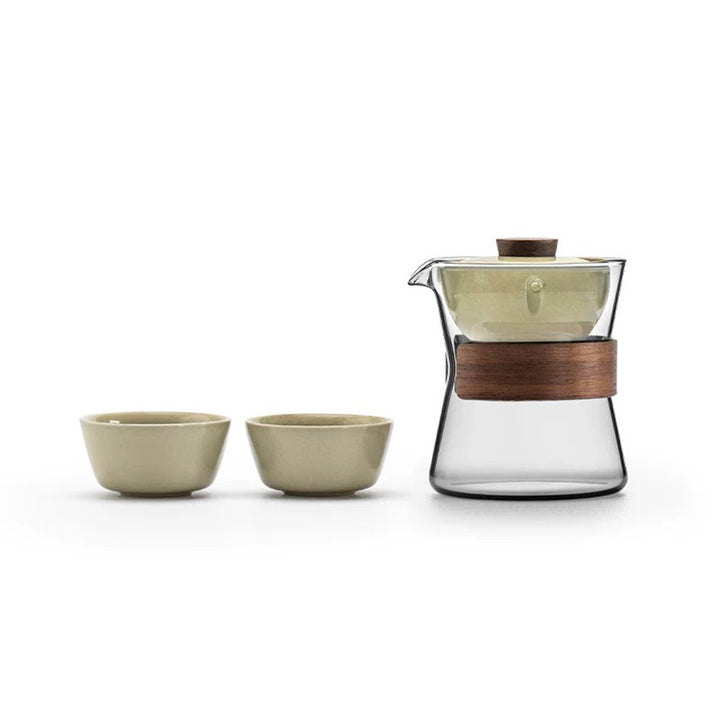 Tea set with glass teapot and two ceramic cups on a white background