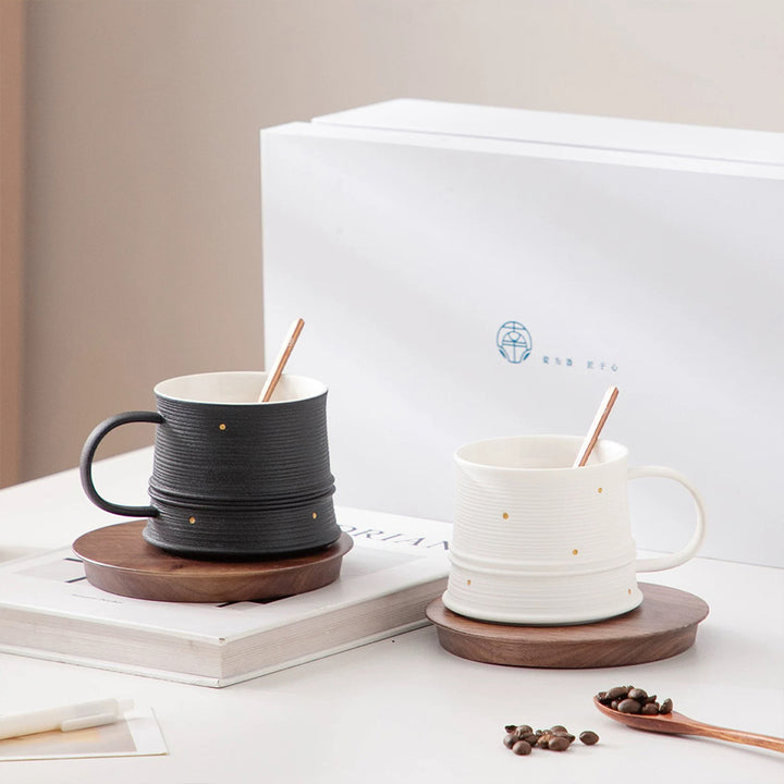 Two ceramic mugs with wooden coasters on a surface with a blurred background