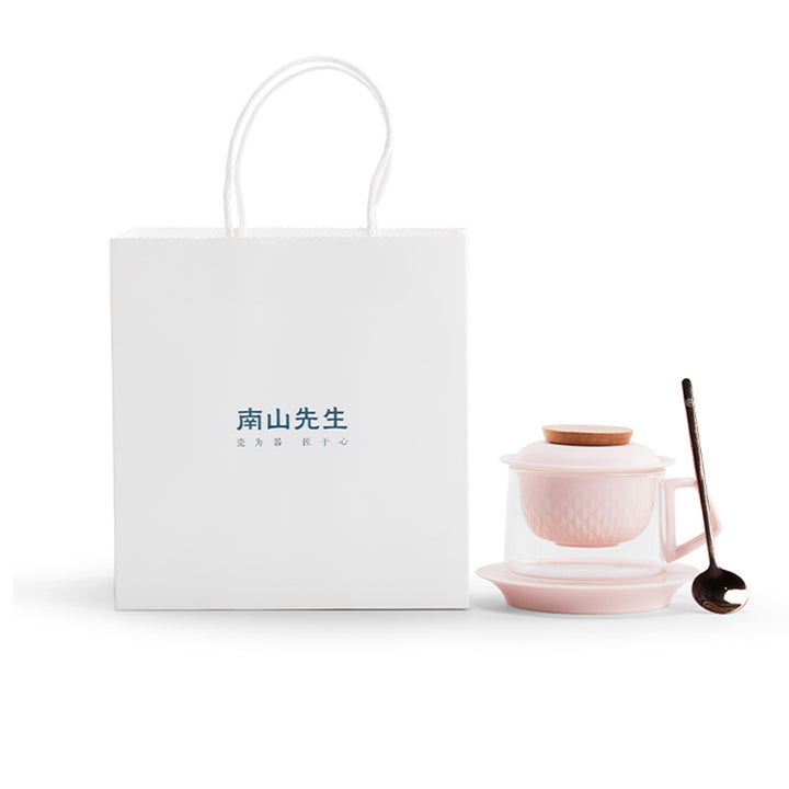 Pink glass tea set with a white box on a white background